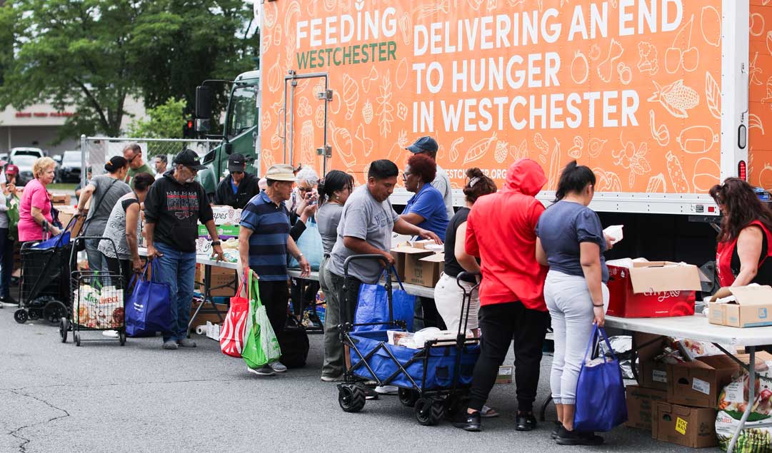 people in a line for food infront of Feeding Westchester Truck