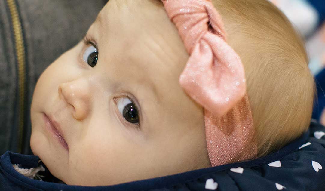 baby with a pink bow looing at us