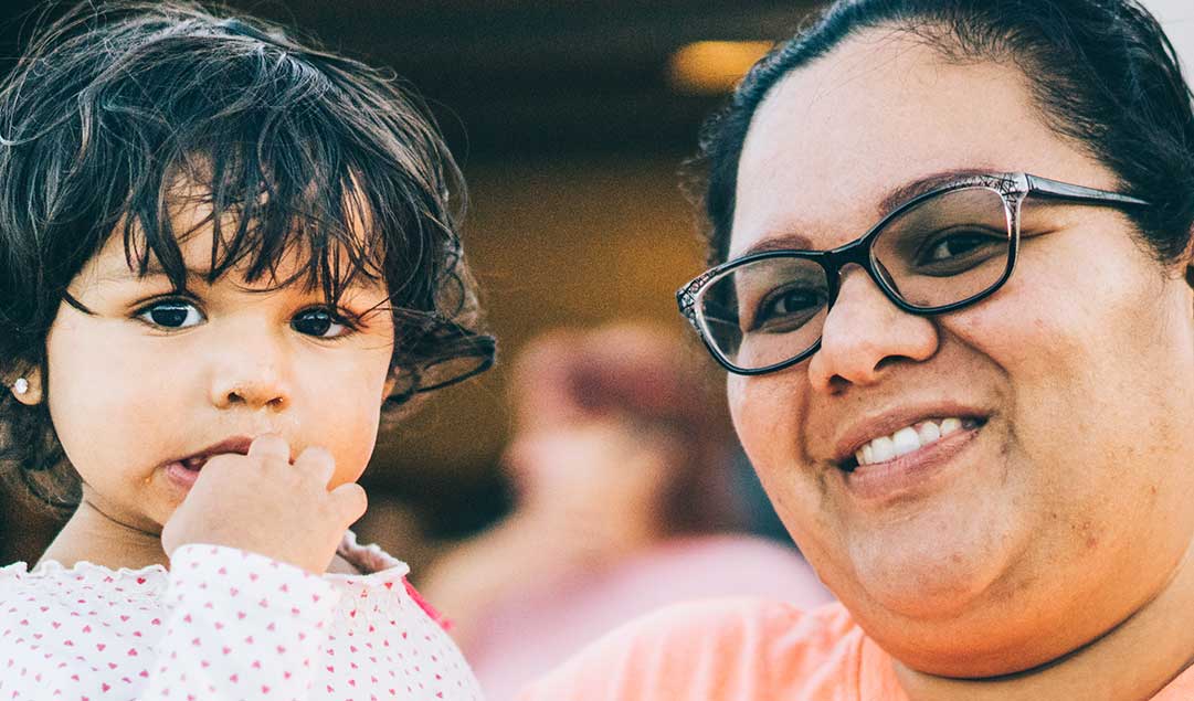 mother holding her small child smiling at the camera