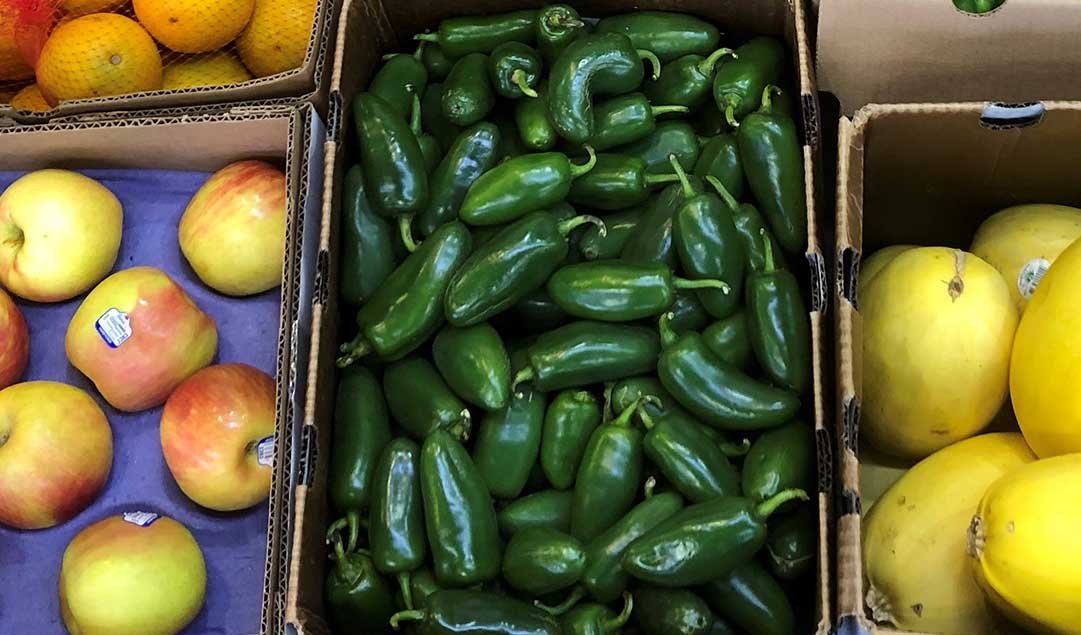 apples, peppers and other vegetables in a box