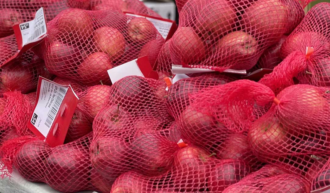 red apples in individual mesh bags