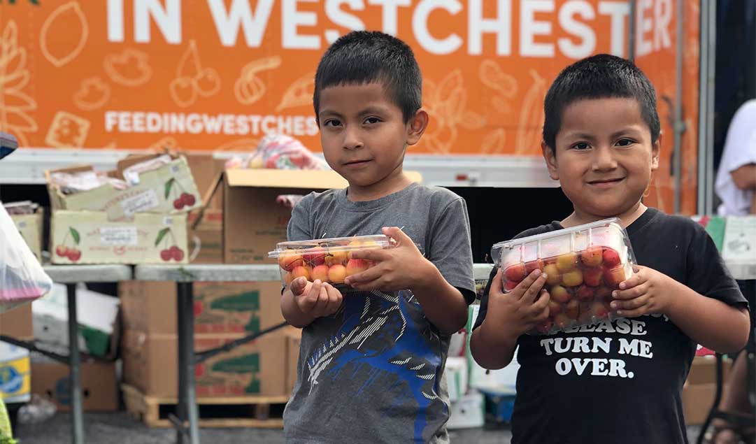 two boys holding food they received from Feeding Westchester