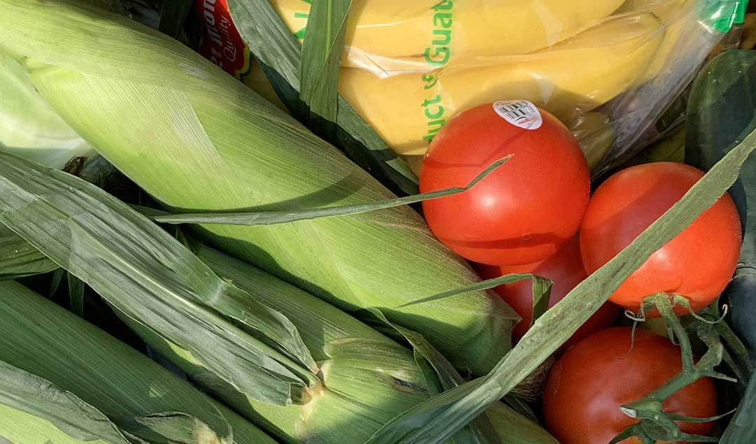corn, bananas and tomatoes in a box