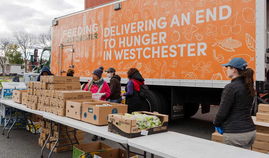 Food distrubution infront of a Feeding Westchester truck