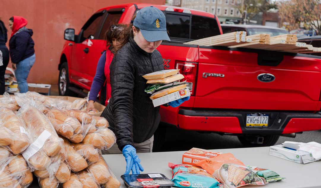 volunteer placing food goods on a table for distribution