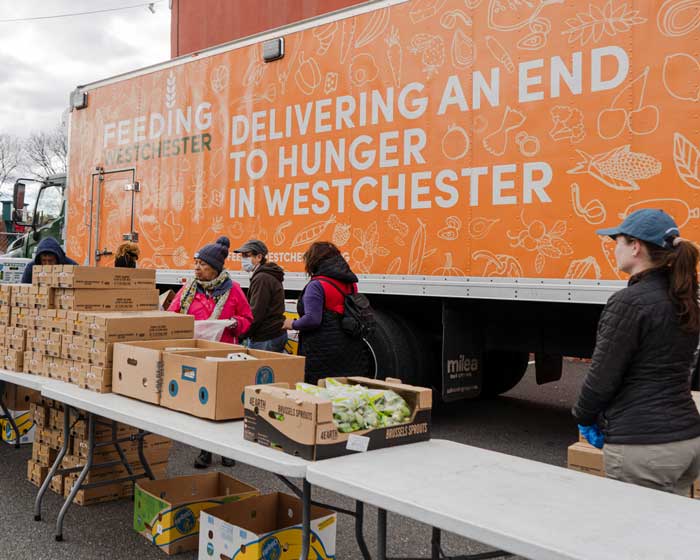 Food distrubution infront of a Feeding Westchester truck