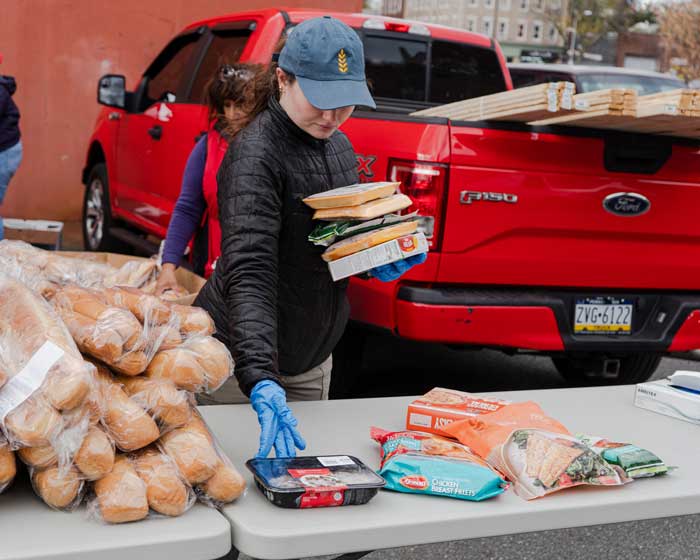 volunteer placing food goods on a table for distribution