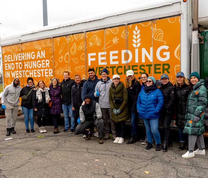 volunteers stadnign infront of Feeding Westchester Truck filled with food for the people